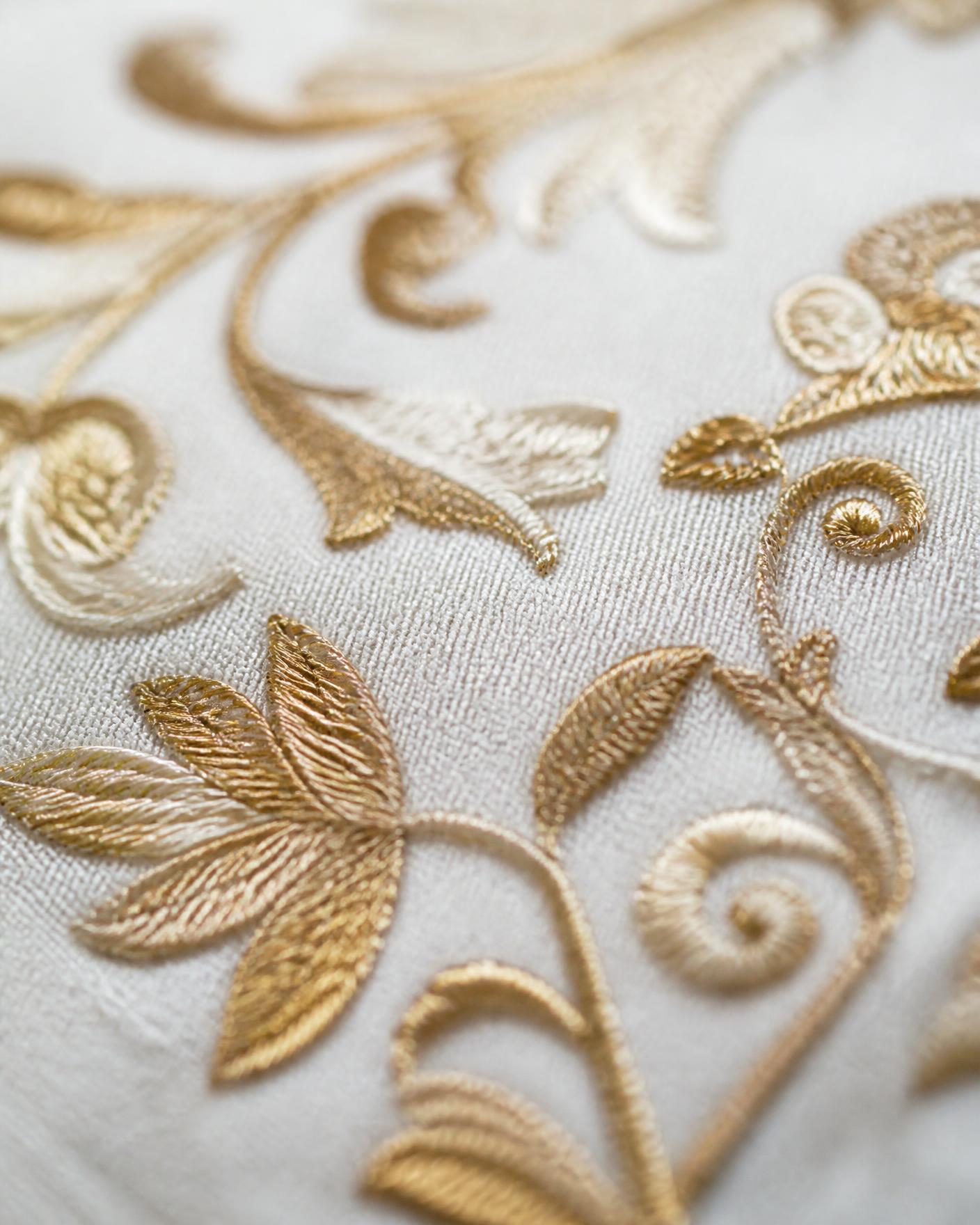 Feine Stickerei in Gold- und Cremetönen